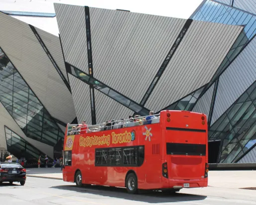 Double-decker bus passing by the Royal Ontario Museum.
