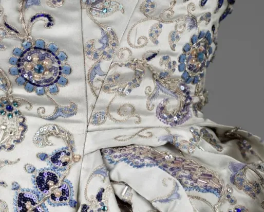 Photo of a white gown with blue jewelled detailing
