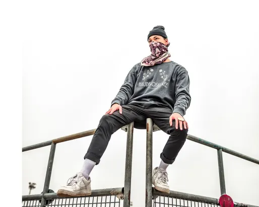 Masked person sitting on bleachers.