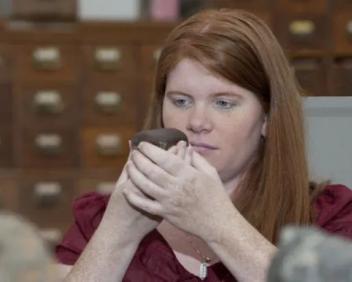 Kim Tait in collection room examining the meteorite.
