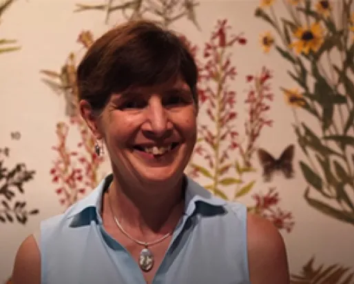 ROM botanist Deb Metsger stands in front of a pressed plant display in the Hands-on Biodiversity Gallery.

