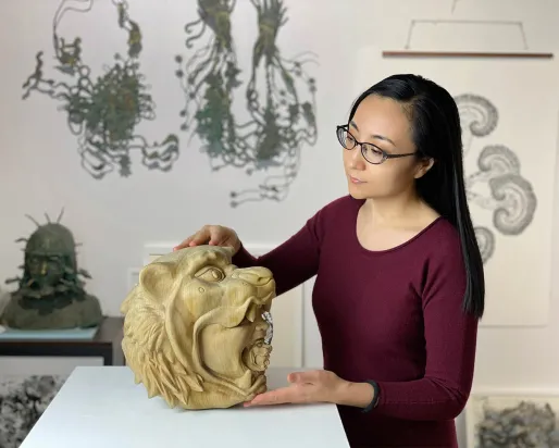 Artisit examining her sculpture.