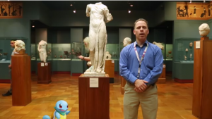 photo d'une homme et d'une tortue en dessin animé devant une statue d'Aphrodite