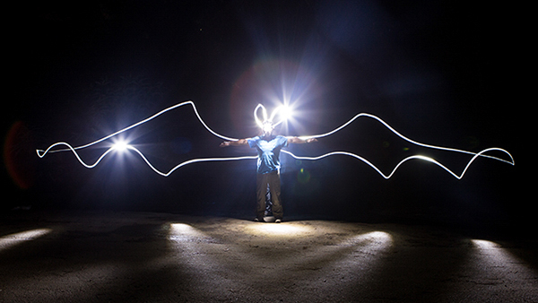 The ROM’s very own ‘Batman’, Assistant Curator of Mammalogy, Dr. Burton Lim with "bat wings" outlined with light in a long exposure photo. Credit: Vincent Luk