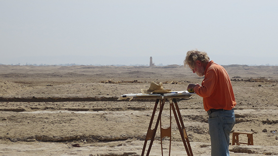 Man at work at an archaeological site with desert in background.  