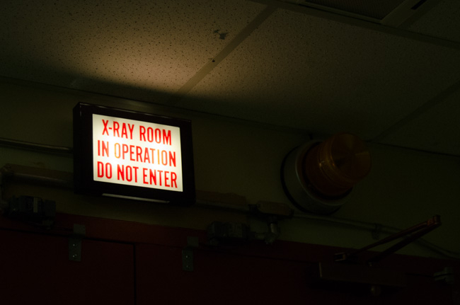the flashing sign in the x-ray lab glows white with red text that reads "x-ray room in operation, do not enter"