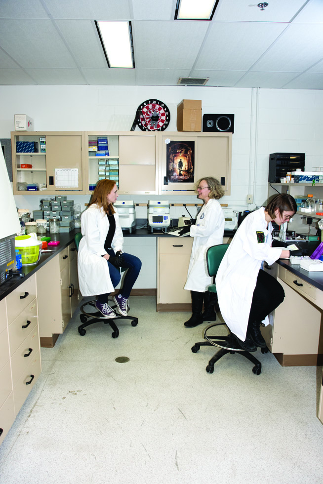 Three women in a lab running DNA testing