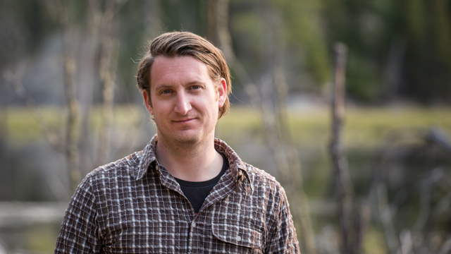 A portrait photo of Sebastian Kvist out in front of a swamp in the field in Minnesota, U.S.A. Photo by Vincent Luk