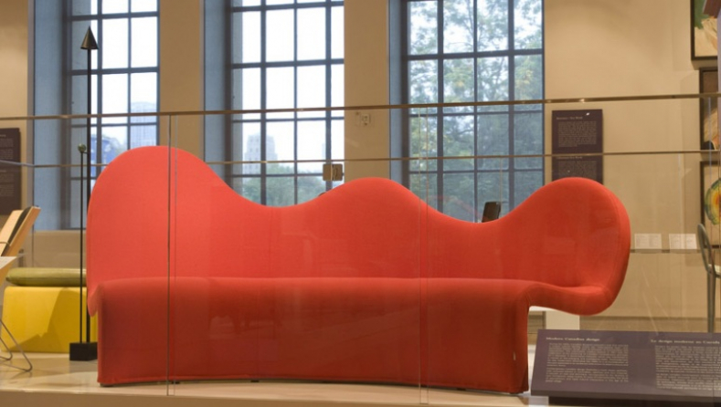 Un long sofa rouge au dossier ondulant