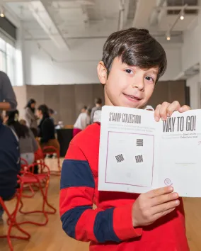 A kid holding up a book.