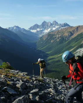 2 hikers going up a mountain search for fossils