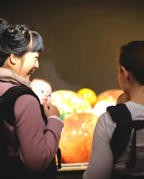 Two mothers carry with their baby in a carrier bag at ROM 