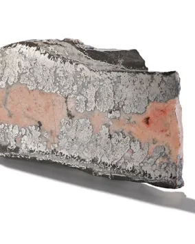 Pie-shaped sample of cobalt mineral encased in smaltite, shown on a white background.