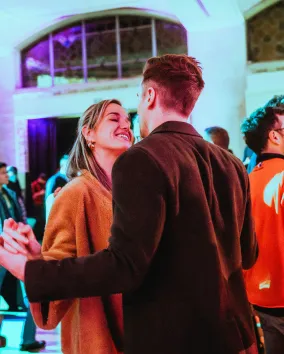 Couple locking hands in a crowd at a museum.