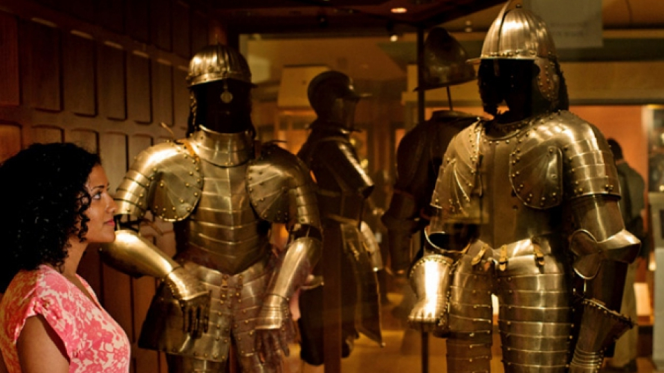 Photo of a woman looking at suits of armour