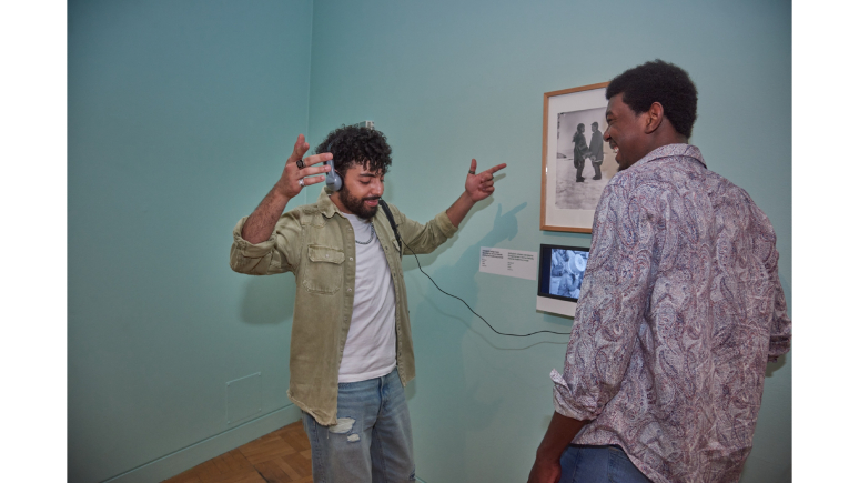 Person enjoying interactive music in exhibition with friend