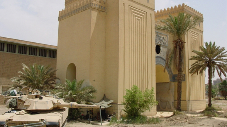 Building with palm trees and damage from war.