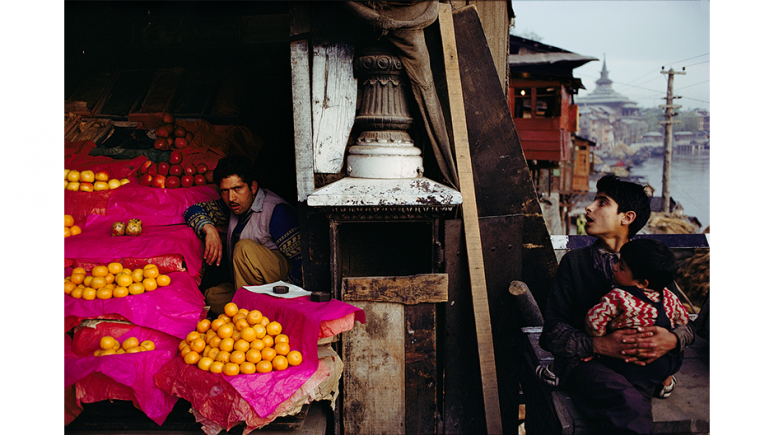 Father and child looking at a fruit seller's stall