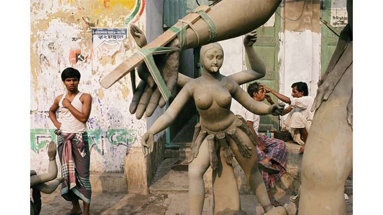 Statue of goddess and a barber shaving a man behind her