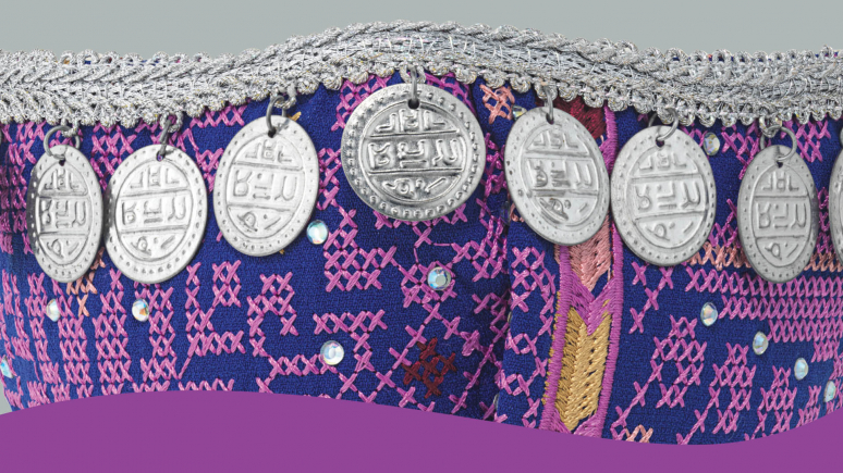 Detail of embroidered purple cloth mask embellished with coins and rhinestones