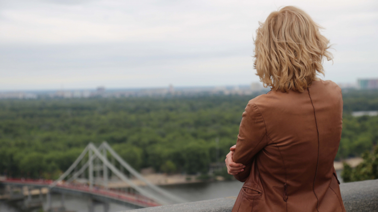 Image looking beyond the back of woman to a Ukraine cityscape