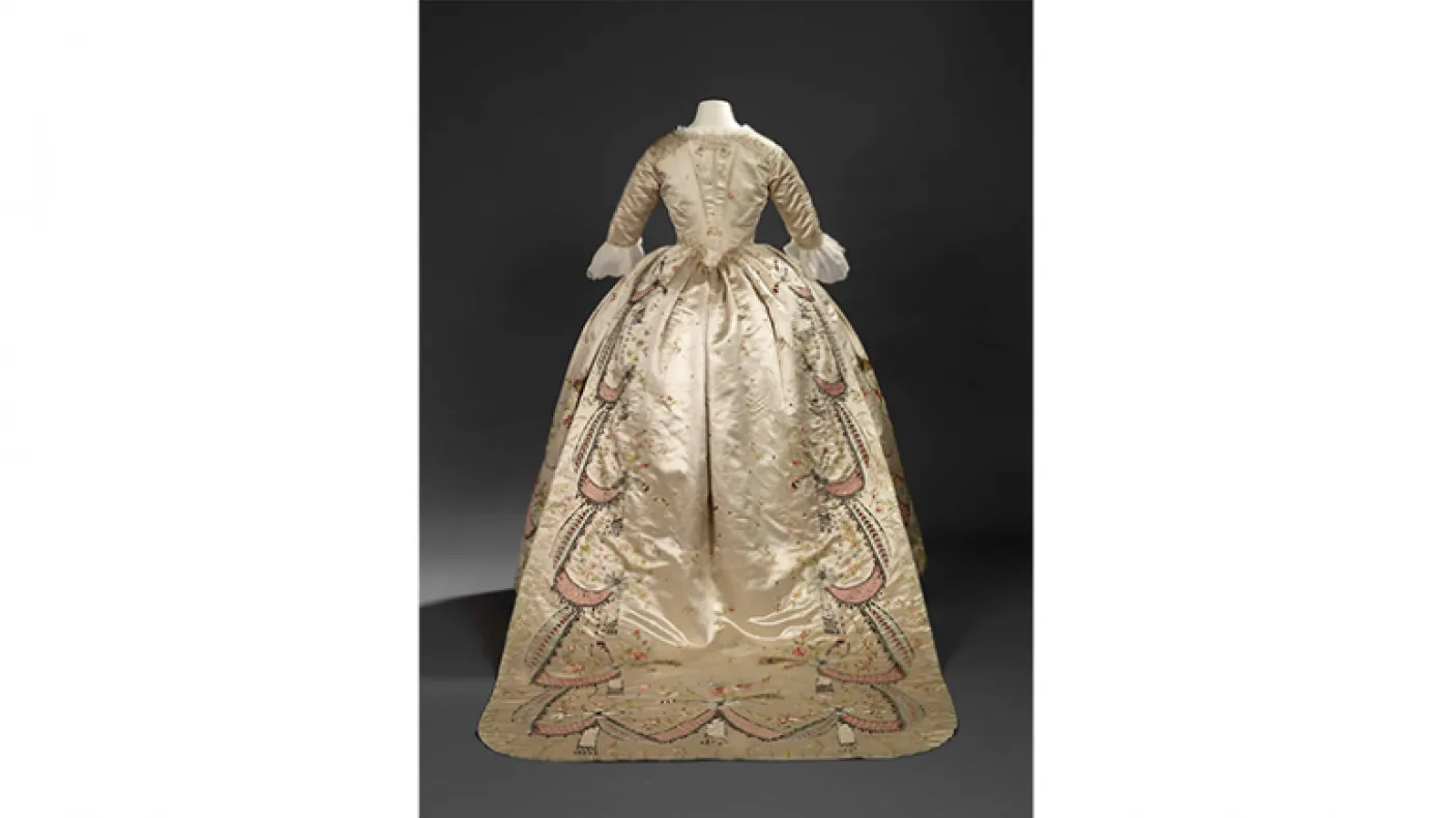 Robe en fourreau. Attribuée à Marie-Jean "Rose" Bertin (couturière française, 1747-1813). France. Années 1780, retouchée dans les années 1870. Satin brodé avec applications de rubans, paillettes, pierres de verre facettées montées sur des parements d'argent, et filé d'argent ; corsage ajusté et désossé. 925.18.3.A.
