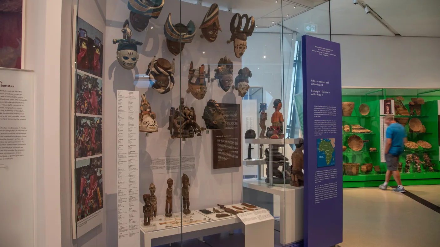 A man looks at an object in a green case, in the foreground you can see masks.
