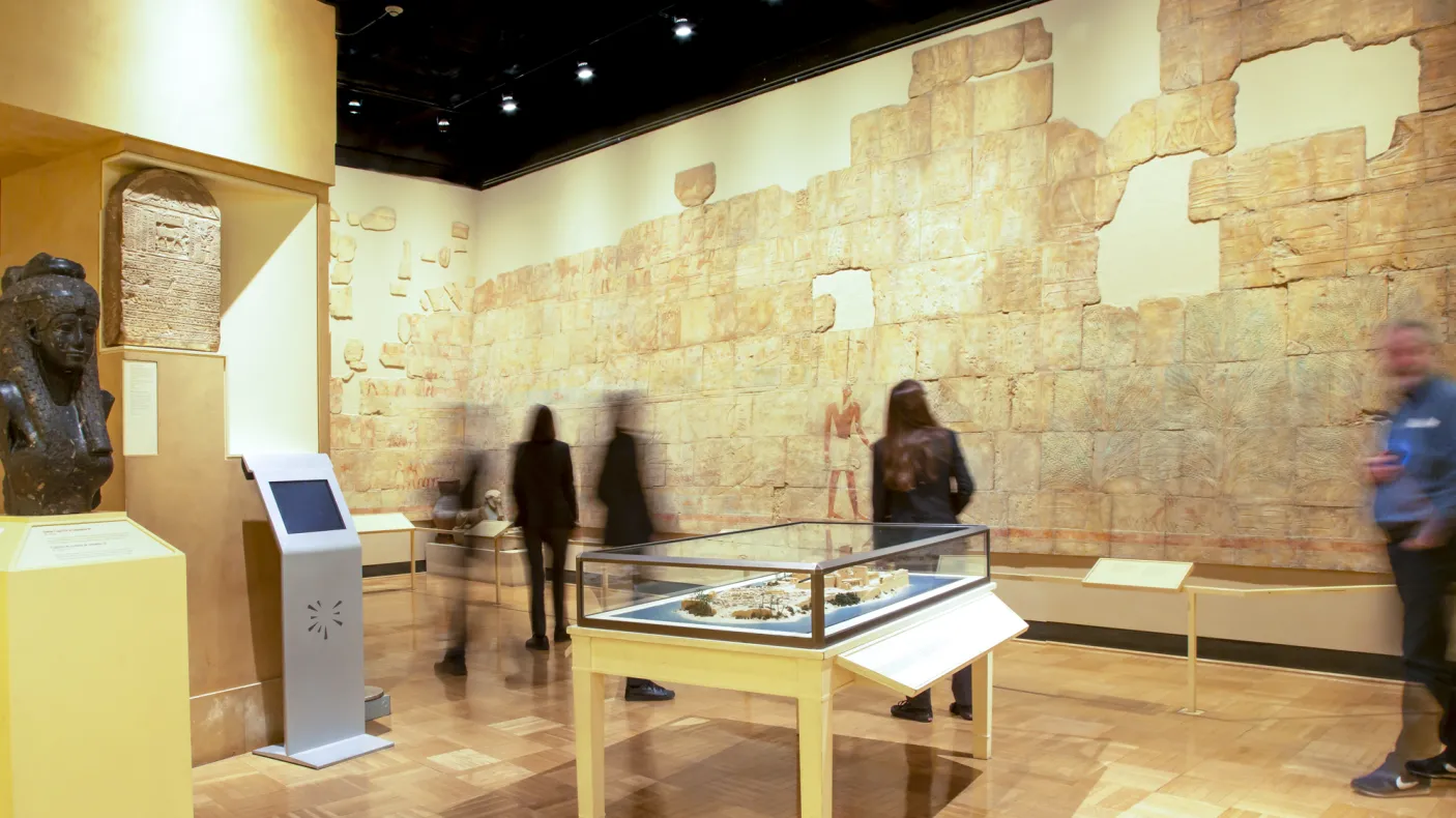People look at the wall of the of the gallery which features a rebuilt painted Egyptian wall.
