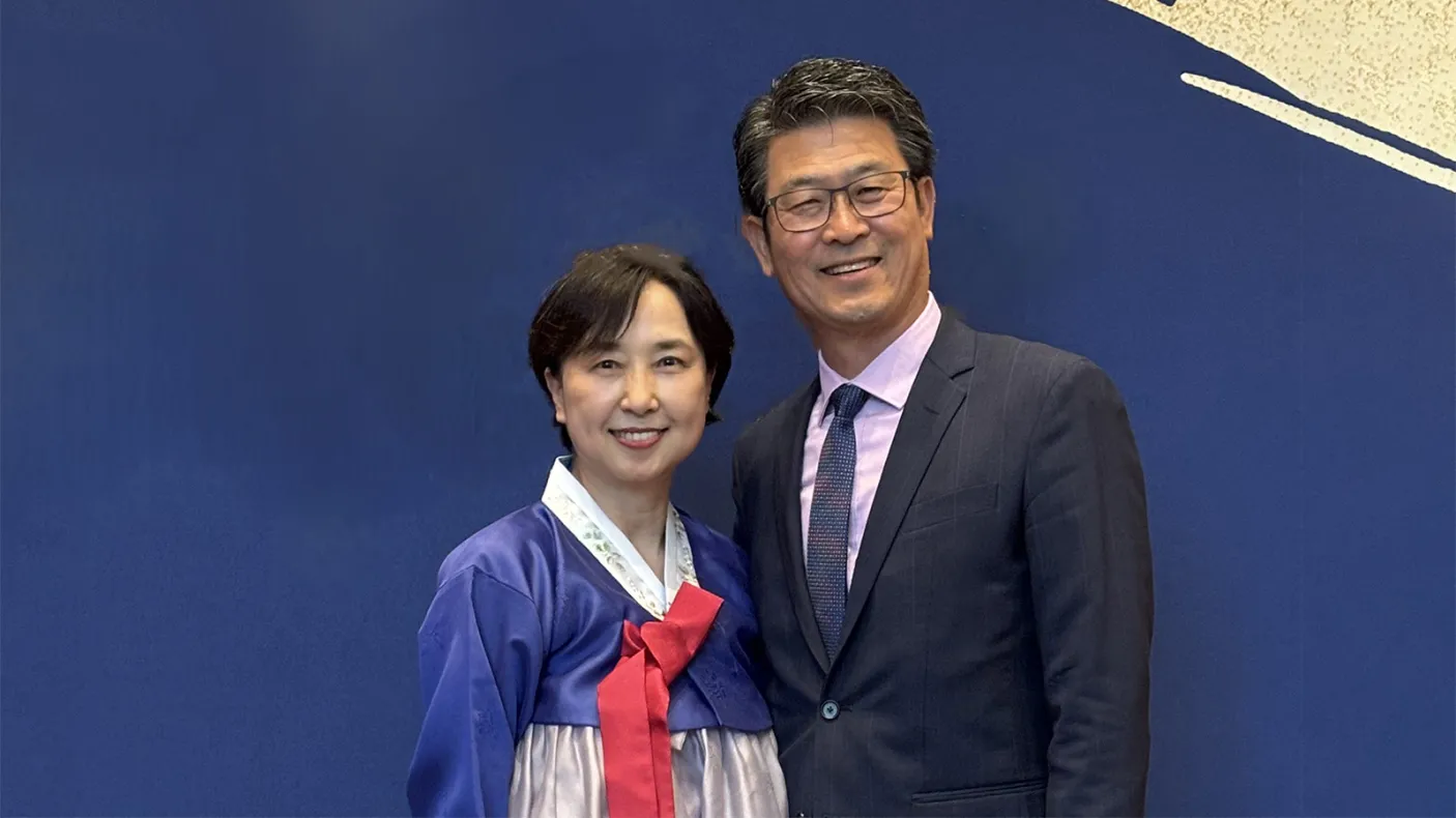 Woman and man in front of a blue background