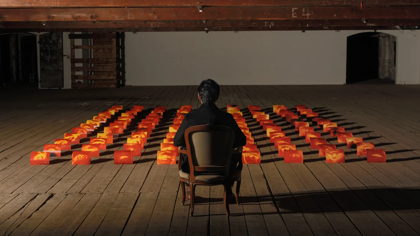 Man sitting in front of photographs.