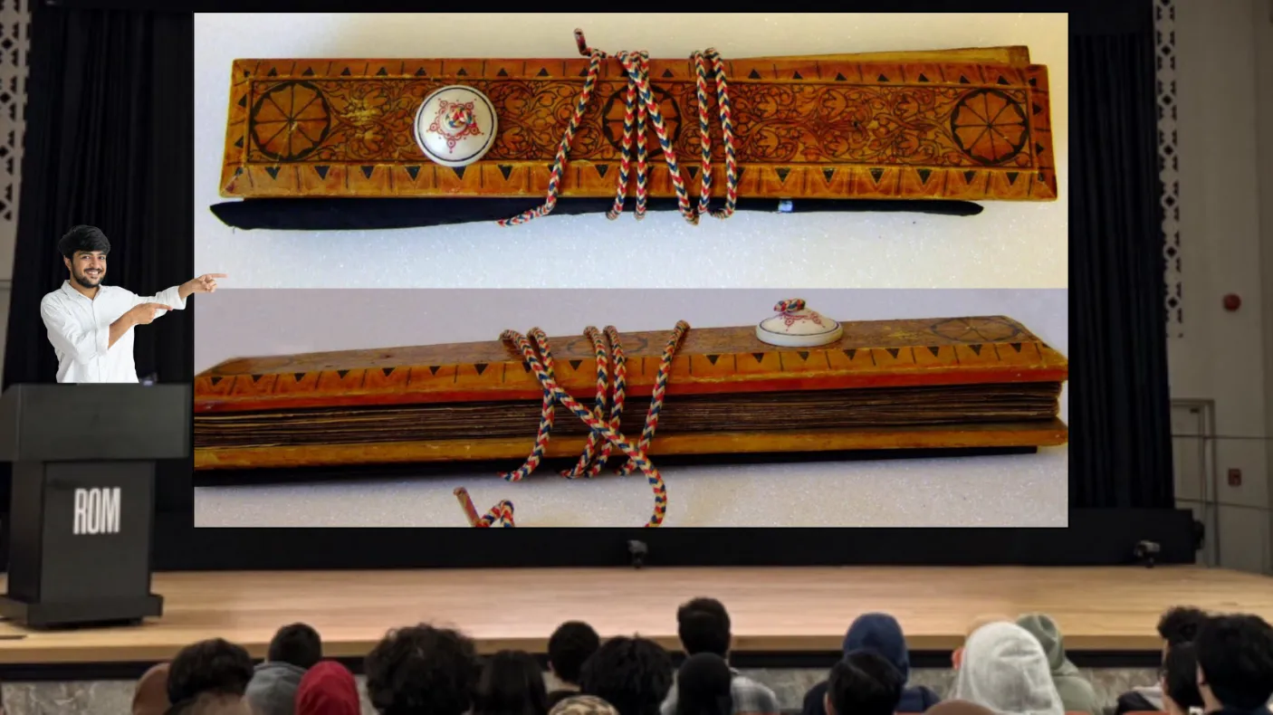 A smiling man stands behind a podium labelled ROM on a stage and gestures at a screen as an audience watches. The screen displays two images of a manuscript held between two ornately decorated wooden covers.