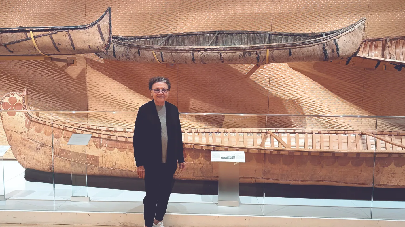 Barbara Nolan, the inaugural Elder in Residence, stands in the Daphne Cockwell Gallery dedicated to First Peoples art & culture. 