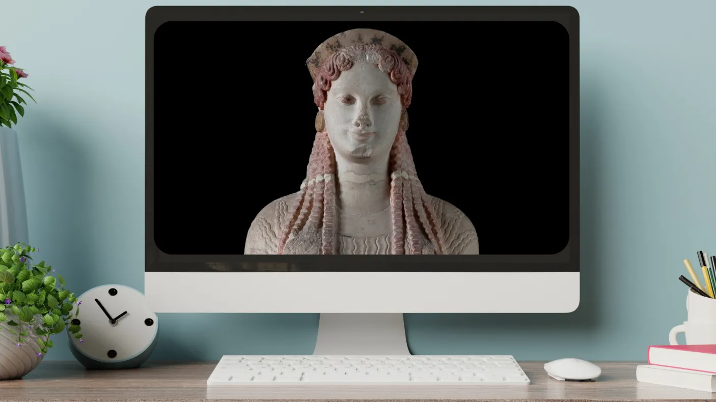 a monitor on a desktop displays an image of a greek statue