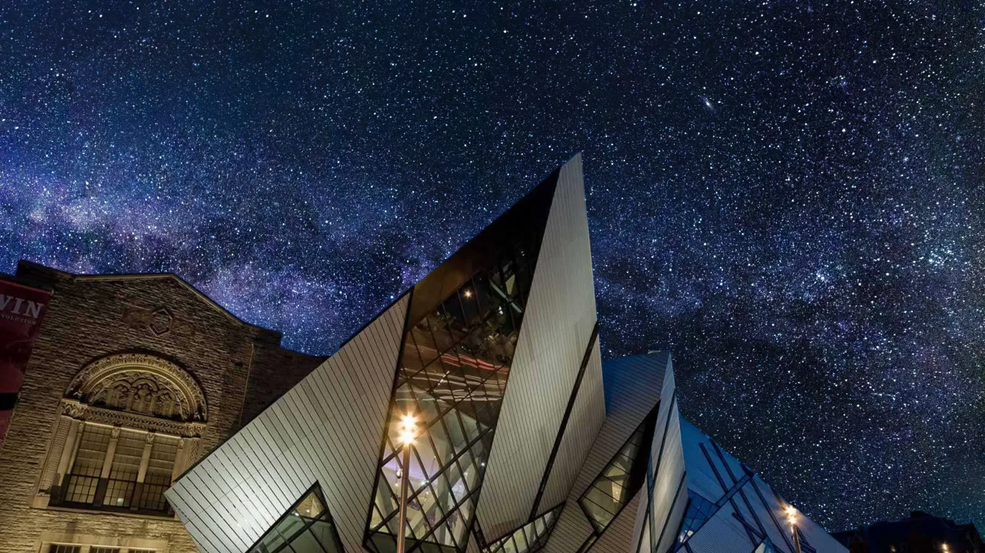 A museum is silhouetted against a dark sky full of brilliant stars