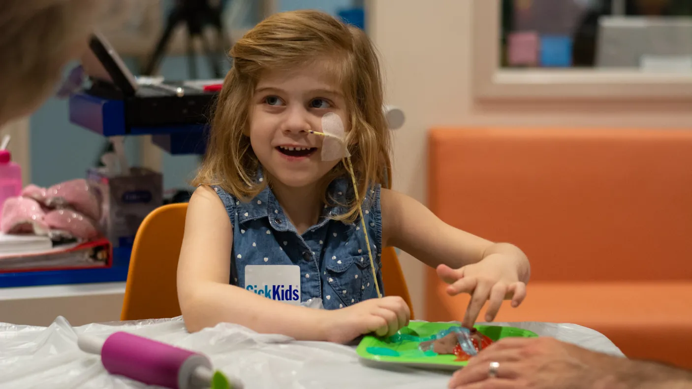 Photo of a girl at Sick Kids doing a dinosaur craft. Photo credit Mark Bernards3
