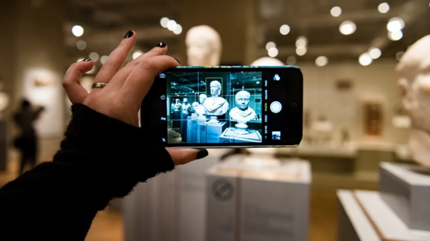 Image of a visitor taking a photo on a smartphone
