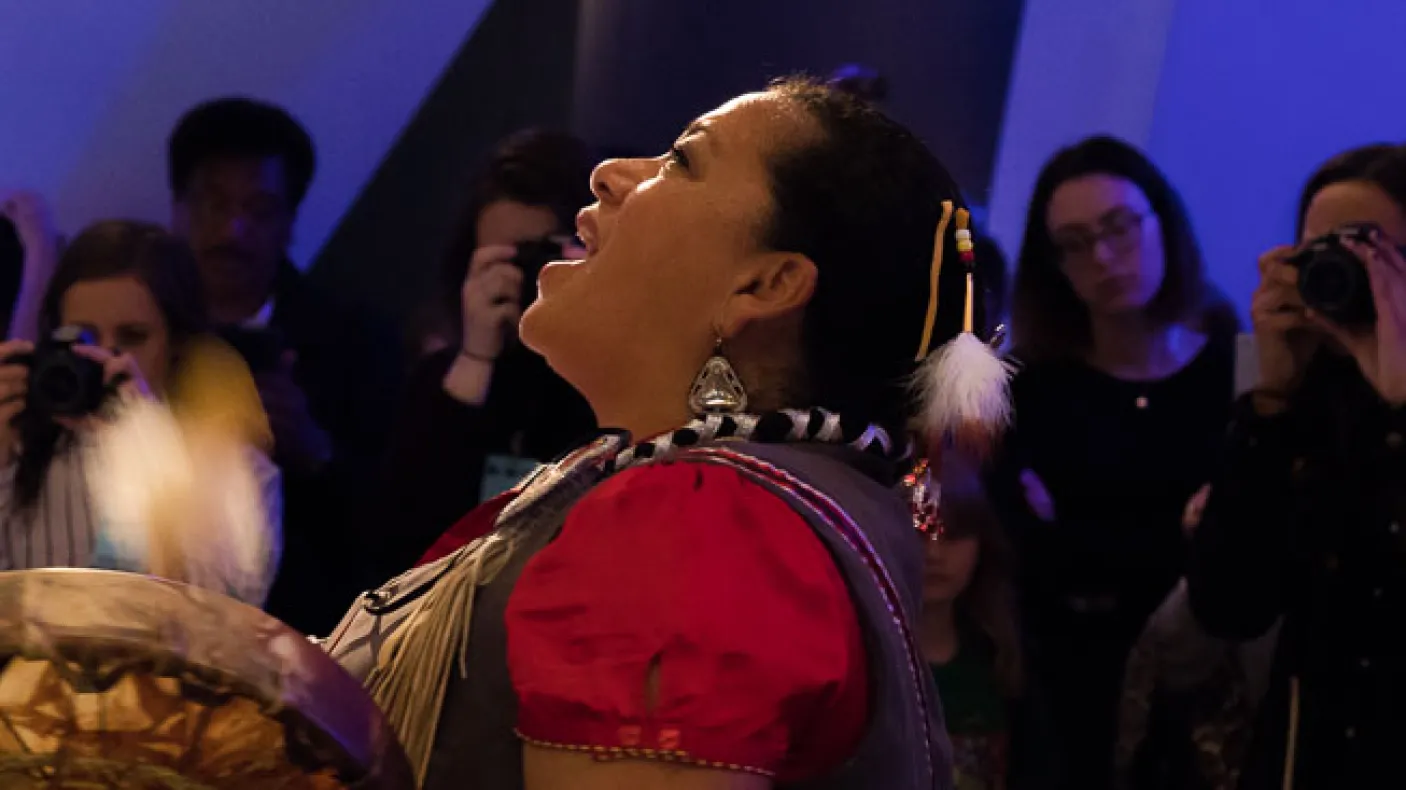 Kim Wheatley joue du tambour et chante une bénédiction Anishnaabe sur le squelette de la baleine bleue. Photo de Rachel Brown
