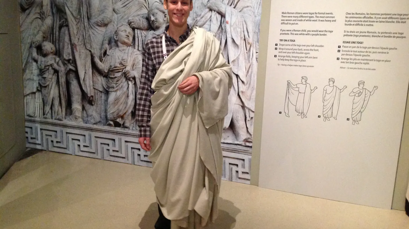 Un jeune homme porte une toge blanche
