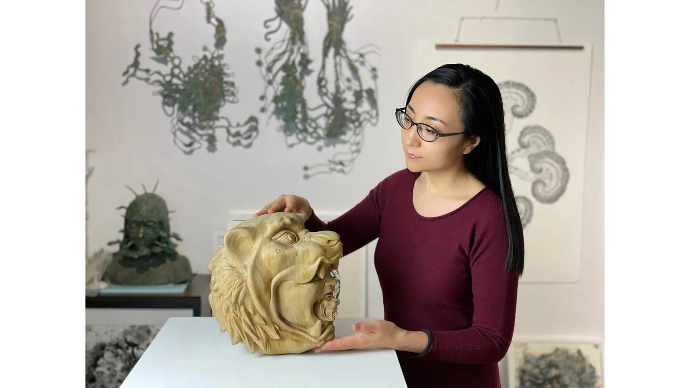 Artisit examining her sculpture.