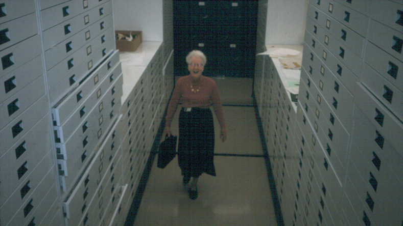 Photo of Dorothy Burnham standing in the textiles storage area.
