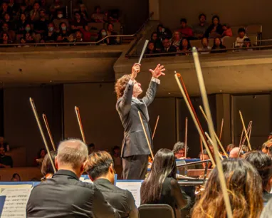 From among the violins, we see TSO conductor Gustavo Gimeno leading the Toronto Symphony Orchestra 