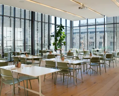 White tables set up in a room with glass windows