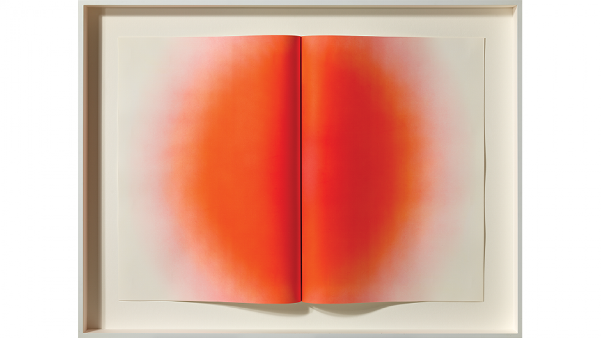 Red sculptural print that looks like a raised book fold with a dispersing red dot in the middle