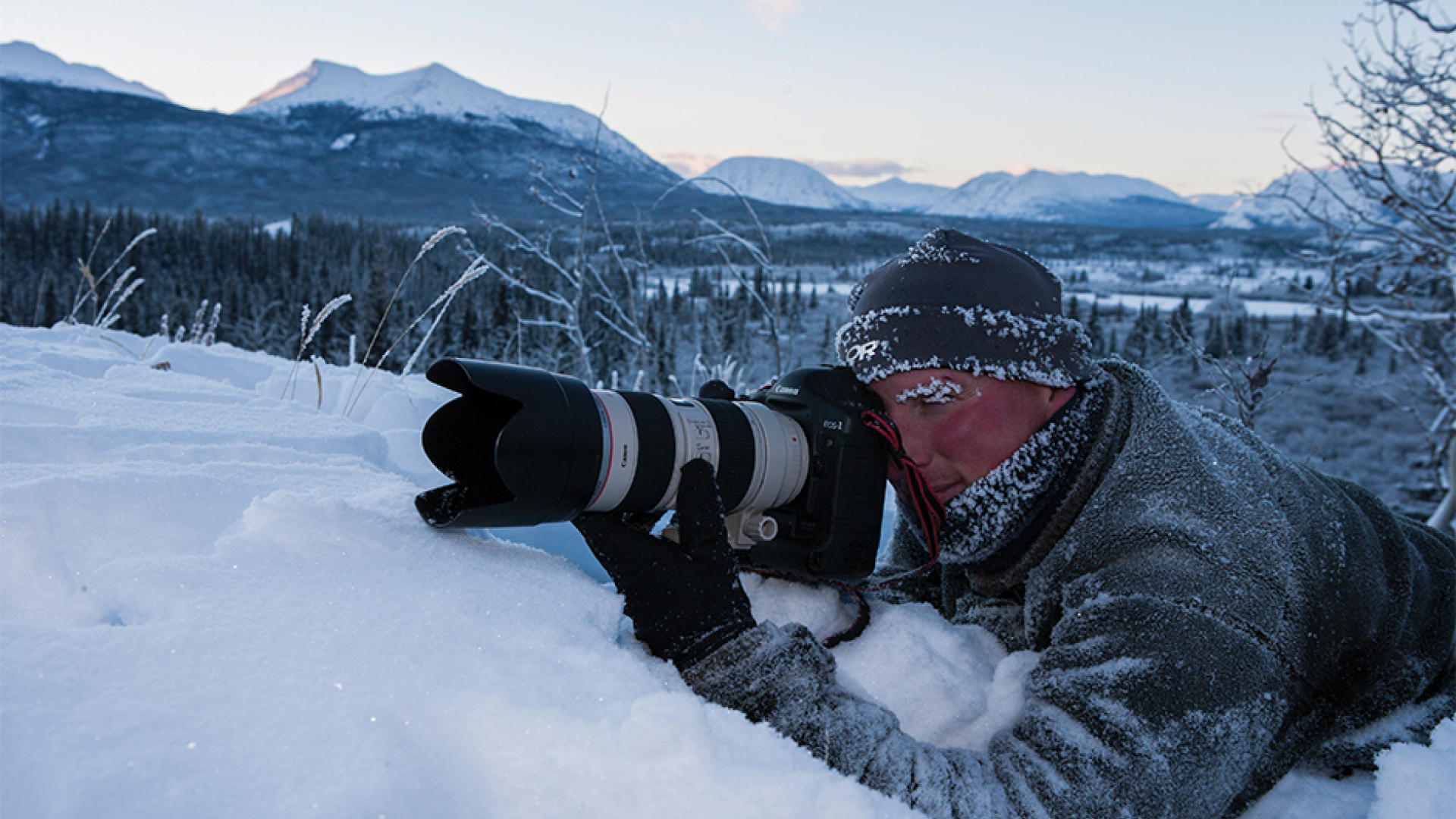 Photographer laying in the snow to get a shot.