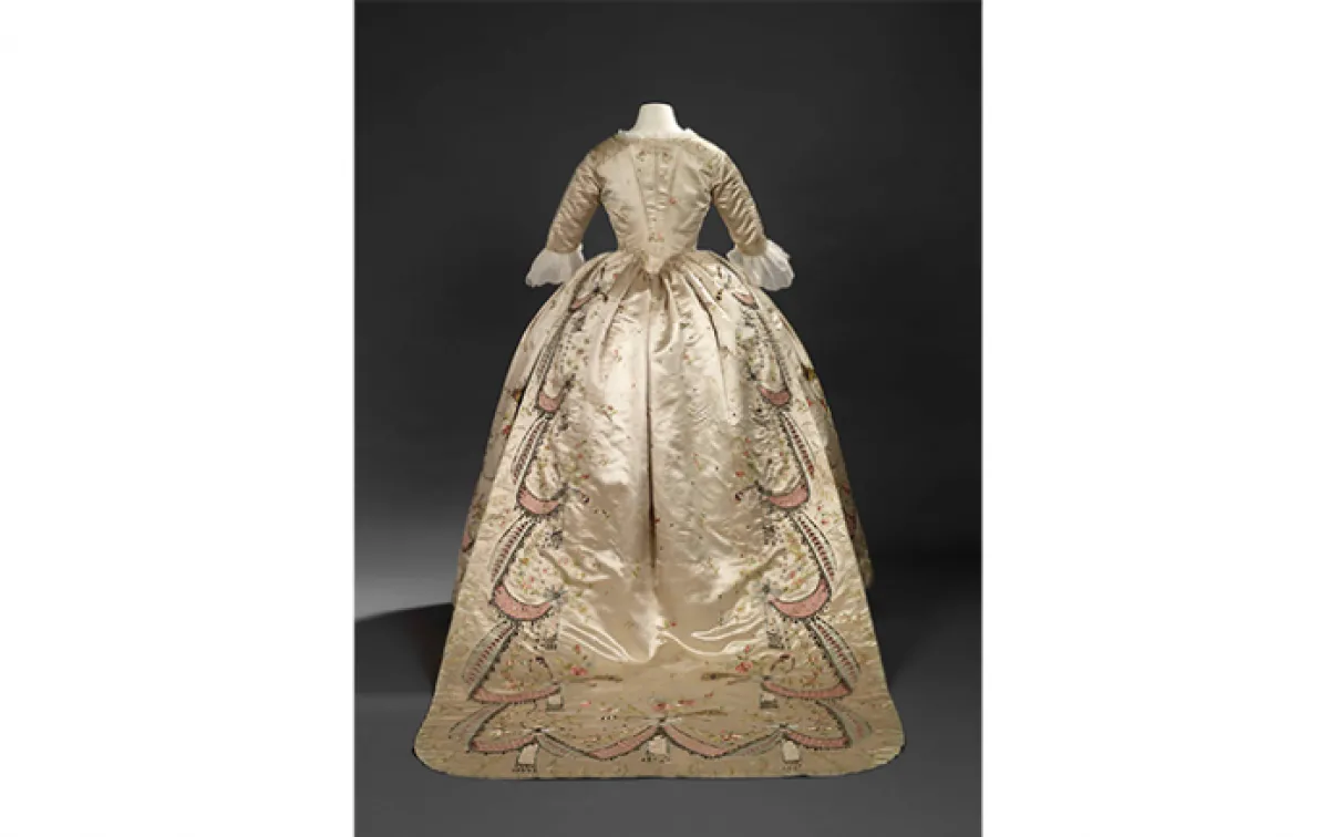 Robe en fourreau. Attribuée à Marie-Jean "Rose" Bertin (couturière française, 1747-1813). France. Années 1780, retouchée dans les années 1870. Satin brodé avec applications de rubans, paillettes, pierres de verre facettées montées sur des parements d'argent, et filé d'argent ; corsage ajusté et désossé. 925.18.3.A.