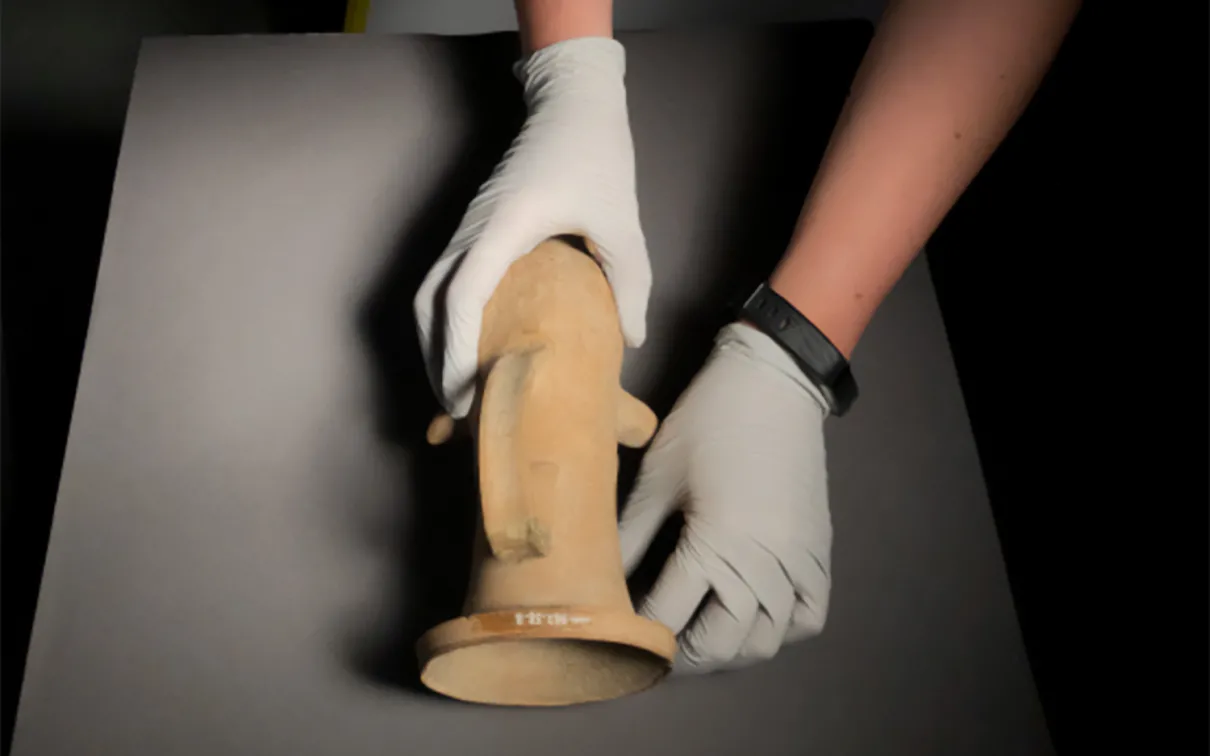 Photographe plaçant avec précaution les objets de collection pour les photographier