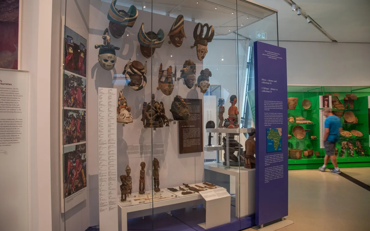 A man looks at an object in a green case, in the foreground you can see masks.