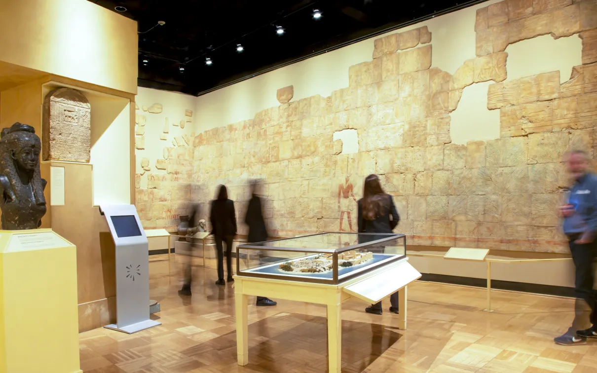 People look at the wall of the of the gallery which features a rebuilt painted Egyptian wall.