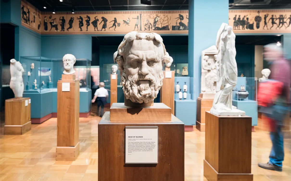 The stern face of Silenos carved in marble stares