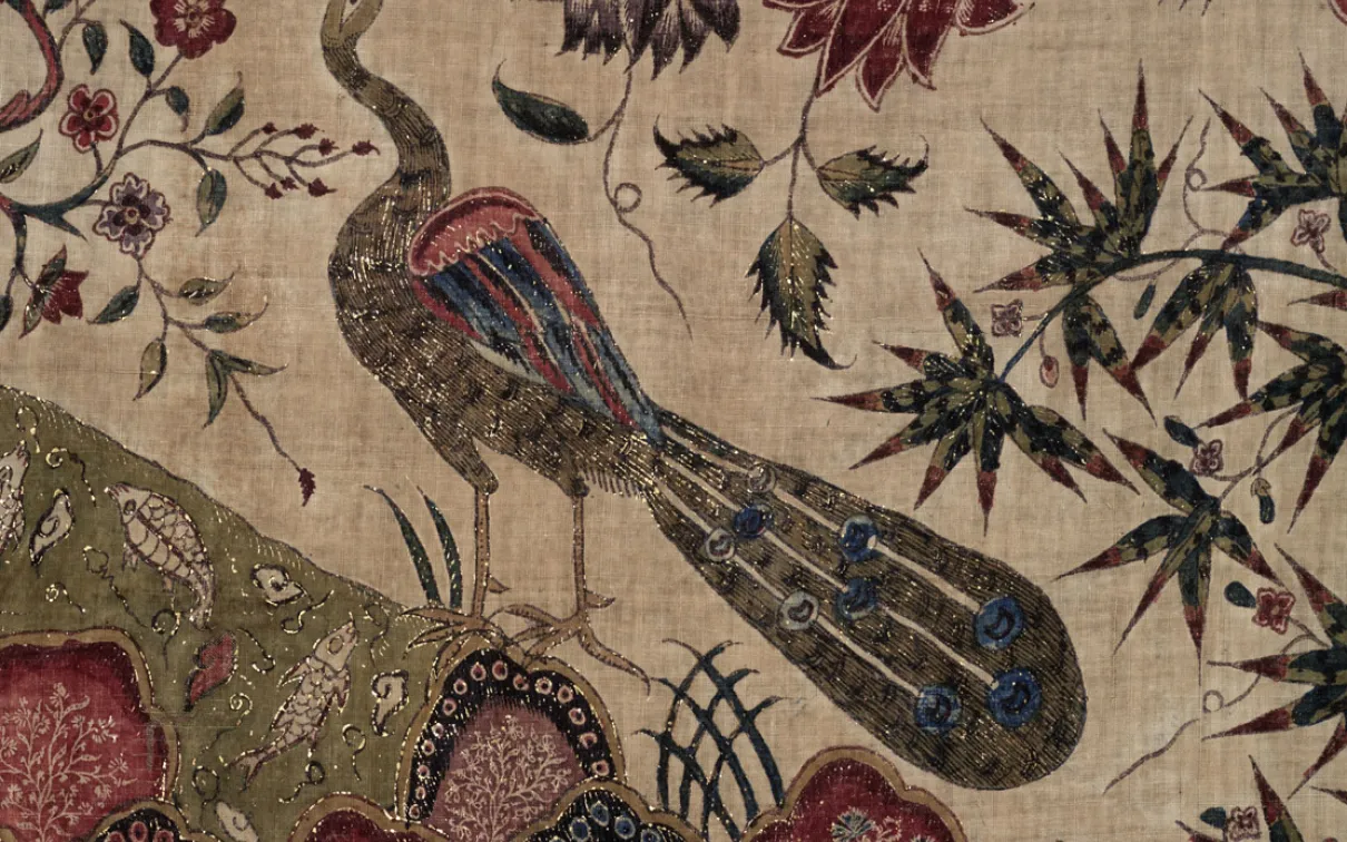 A vibrant tapestry featuring a peacock surrounded by an array of colorful flowers, showcasing intricate designs and textures.